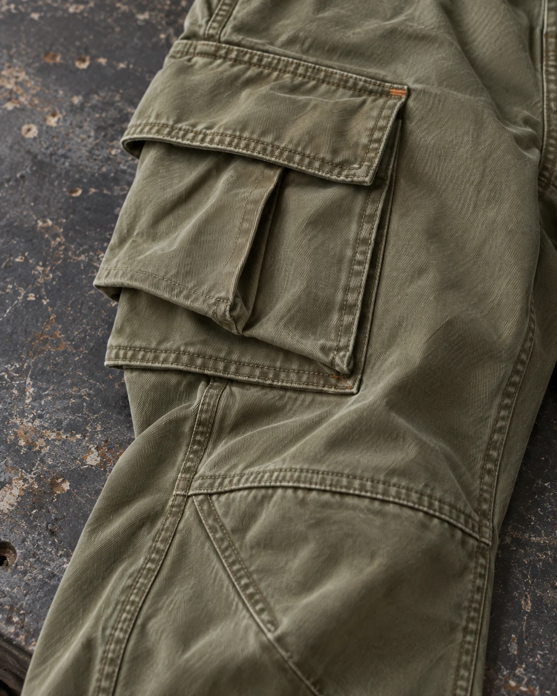 Close-up of fabric and signature construction — Baggy Cargo Pants in washed olive / rust, AI-generated design concept
