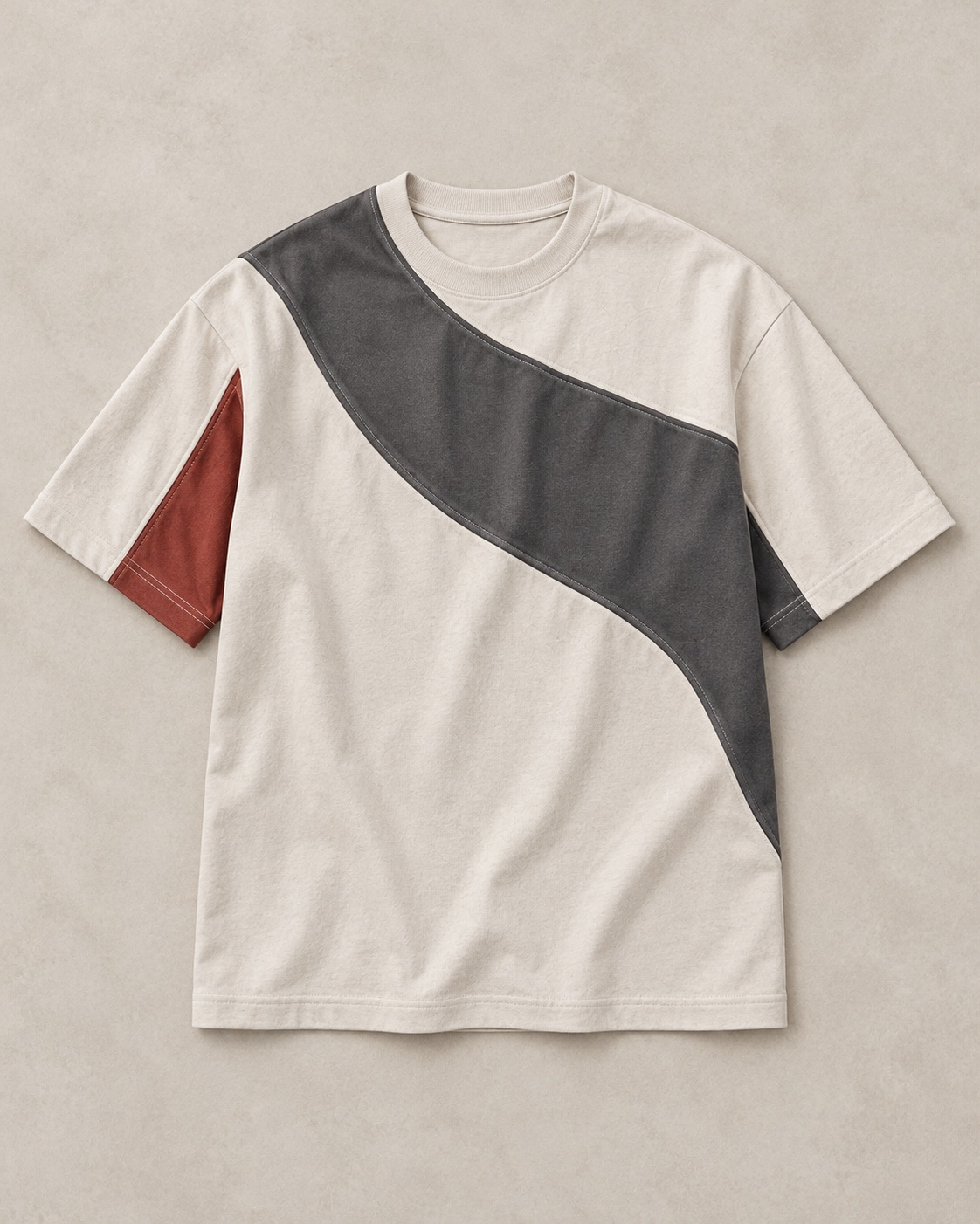 Full garment flat-lay of the original cut-and-sew panel t-shirt concept in chalk / charcoal / clay