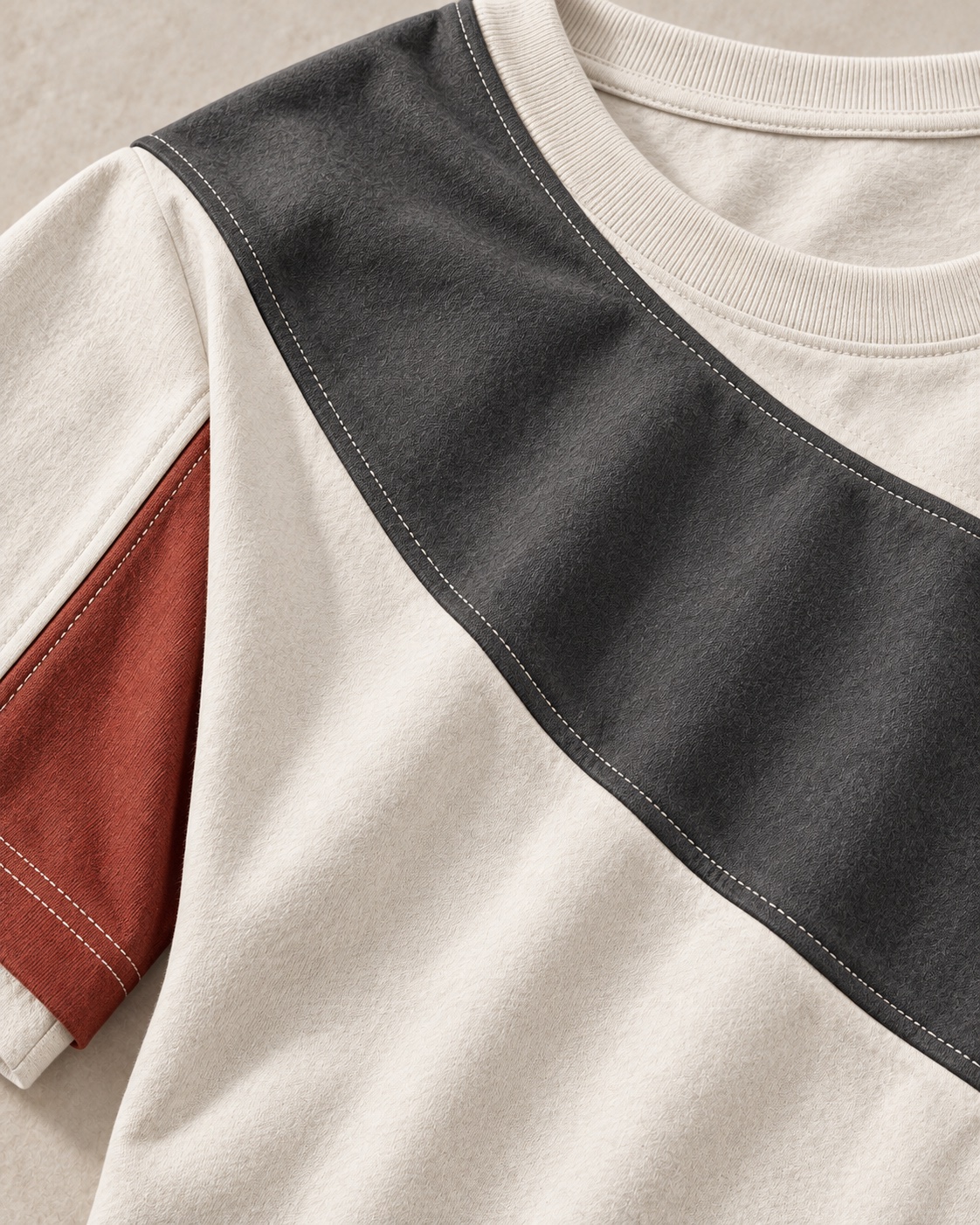 Fabric and construction close-up of the original cut-and-sew panel t-shirt concept in chalk / charcoal / clay