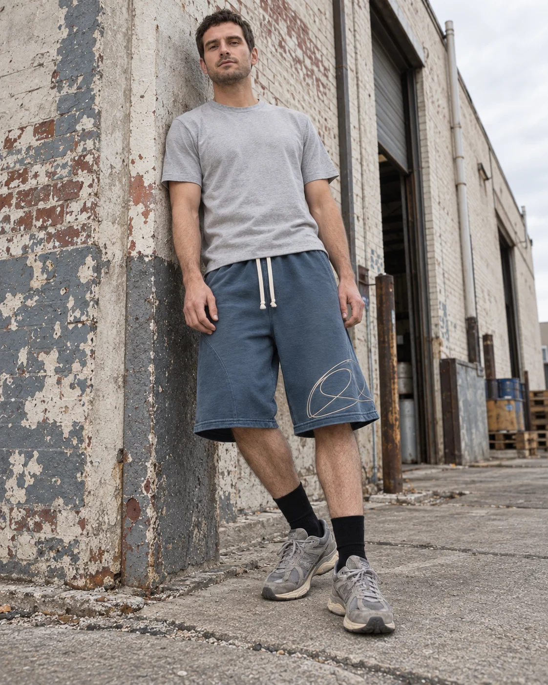 Full-body streetwear styling — Heavyweight Sweat Shorts in faded petrol / cream, AI-generated design concept