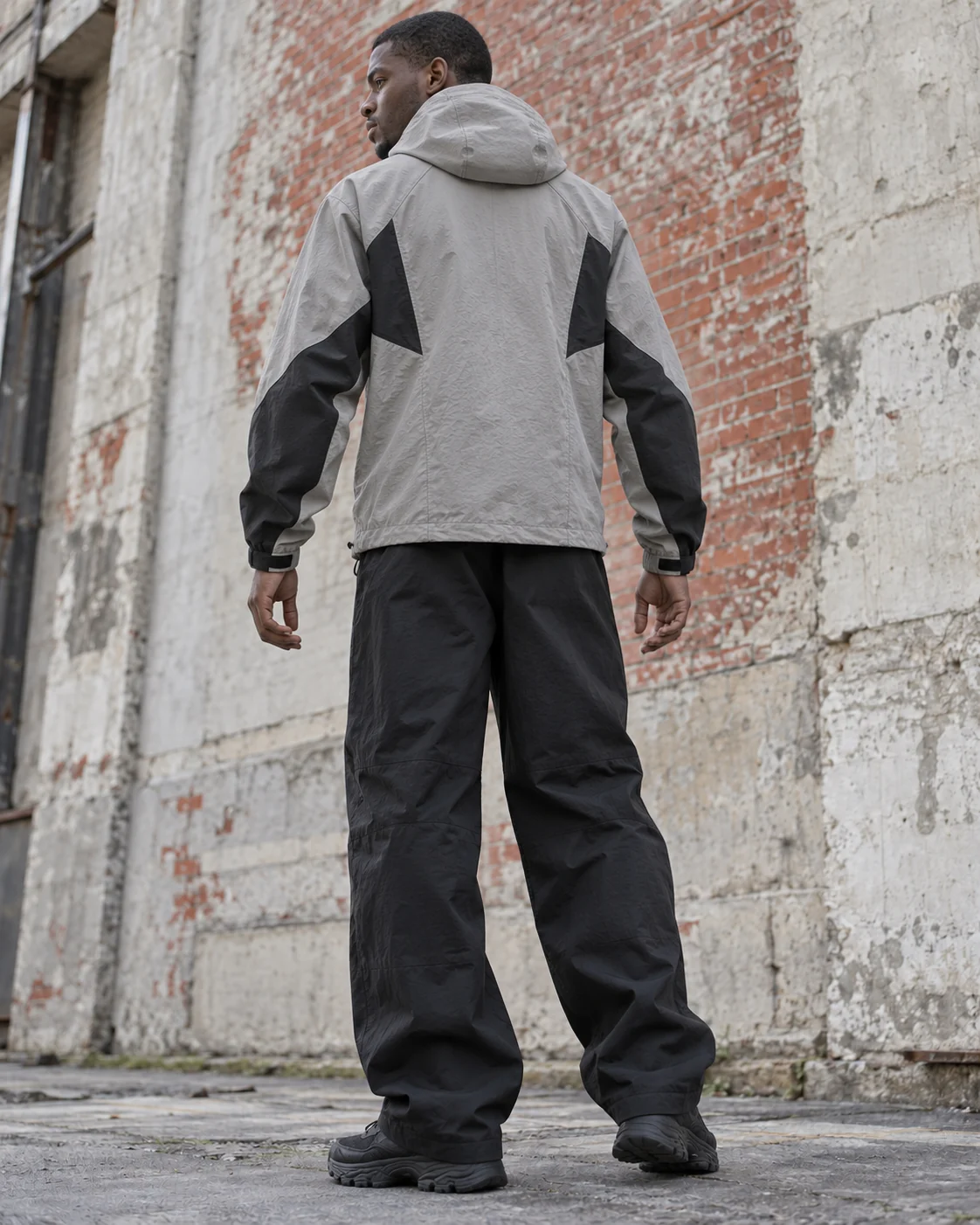 Distinct back design on the same model — Hooded Shell Jacket in stone grey / charcoal / cobalt, AI-generated design concept