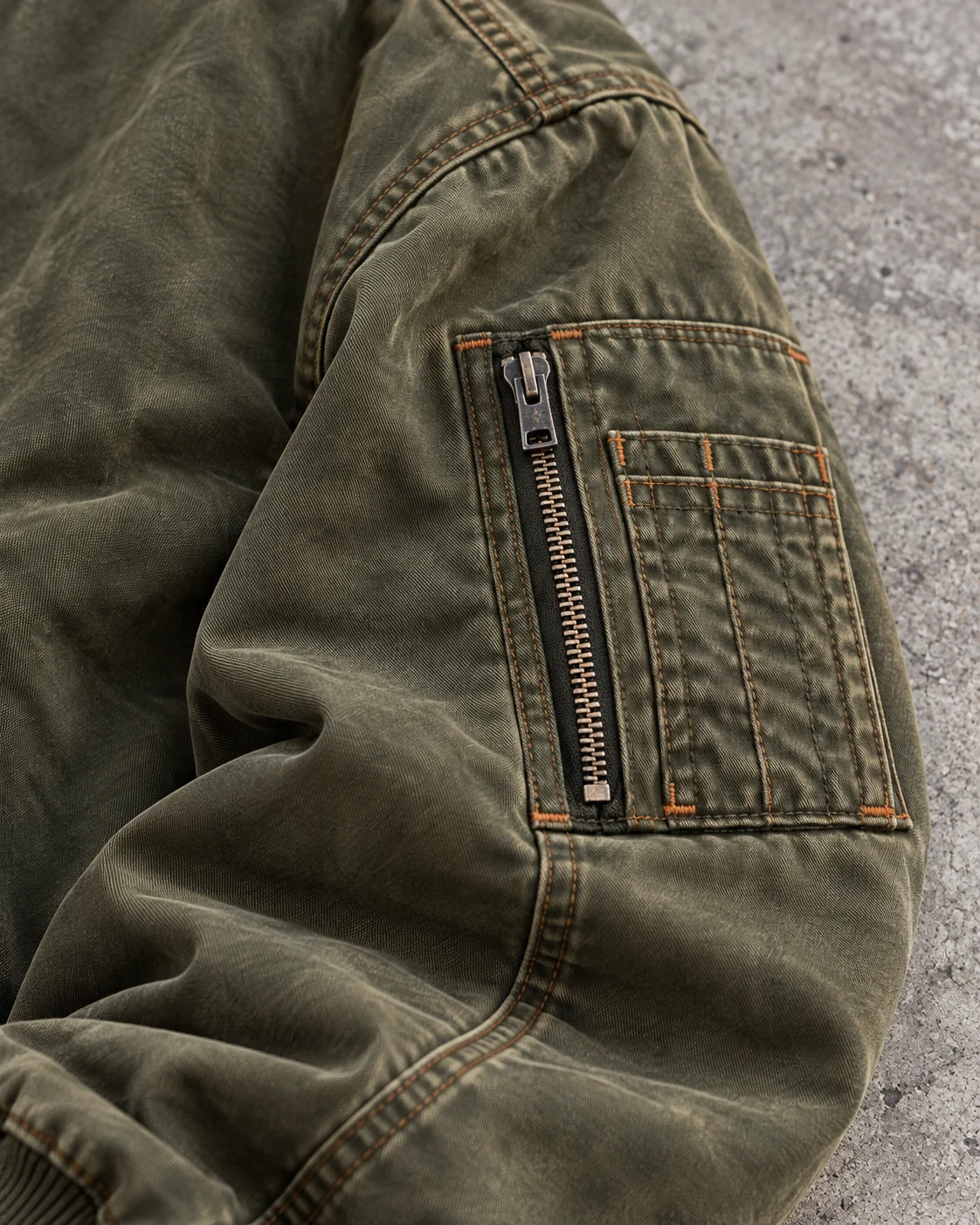 Close-up of fabric and signature construction — Oversized Bomber Jacket in washed olive / rust, AI-generated design concept