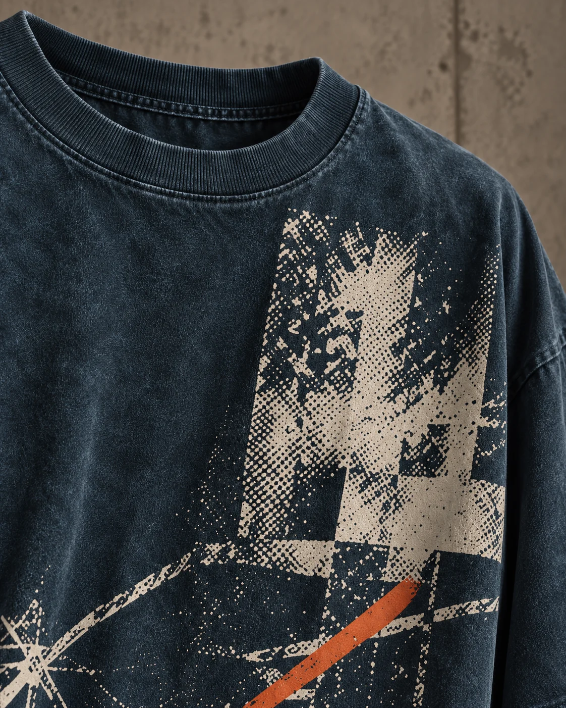 Close-up design concept showing rib collar, textured petrol-blue cotton jersey and cream halftone graphic with orange accent