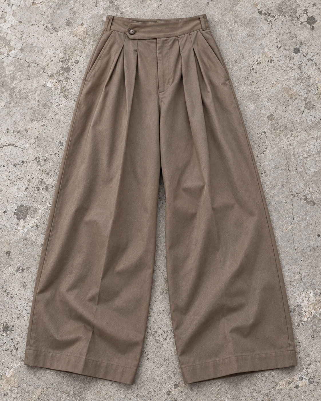 Full garment flat-lay showing the cut — Pleated Wide-Leg Trousers in warm taupe / tonal, AI-generated design concept